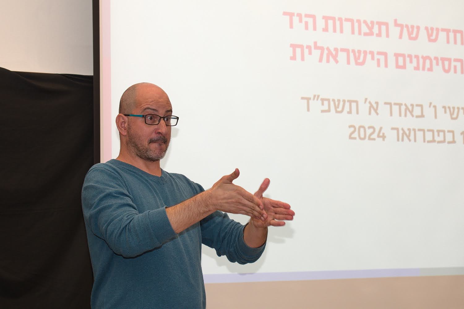 Closeup of a person’s hands as they teach Israeli Sign Language to a class.